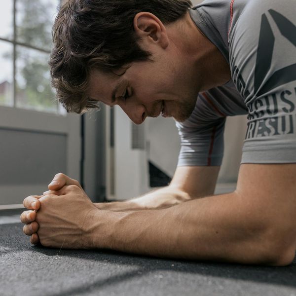 Man in a plank position, showing core strength and focus.